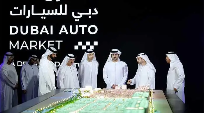 Men discussing a model city layout.